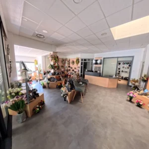 Espace de vente et magasin d'articles funéraires présentant urnes, fleurs artificielles et plaques commémoratives.